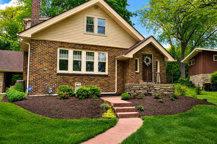 Fresh mulch beds and a stamped concrete walkway at a Milwaukee bungalow