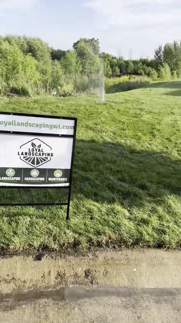 Newly installed sod lawn being watered in around a new-construction home