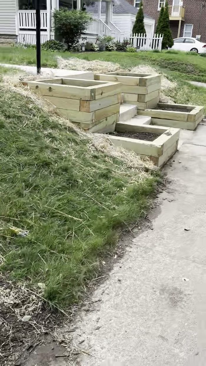 Terraced timber retaining wall and planter boxes running alongside a driveway
